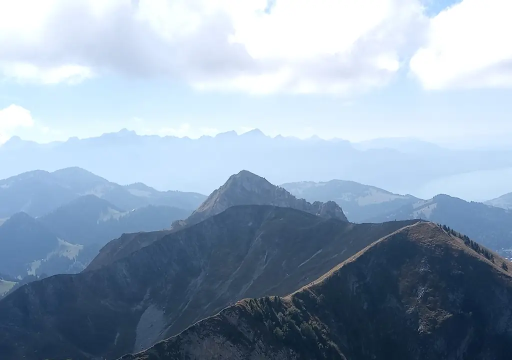 Layered ridgelines above a green valley, a dark grass ridge in front